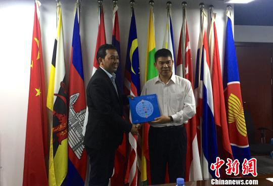 中國—東盟博覽會秘書處副秘書長黃平西（右）與柬埔寨新聞部新聞與傳播總司副總司長春占皮侖（左）互贈禮物。