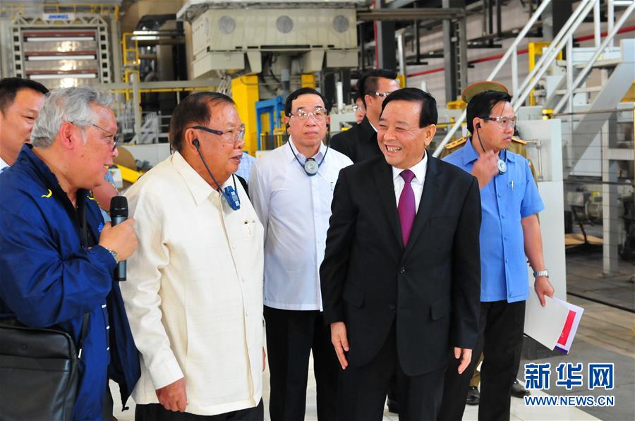 3月10日，在老撾沙灣拿吉省車邦縣，老撾人民革命黨中央總書記、國家主席本揚（左二）在山東太陽紙業(yè)股份有限公司董事長李洪信（右二）的陪同下視察公司。 新華社記者章建華攝
